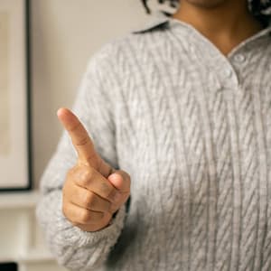 black woman pointing finger in light room